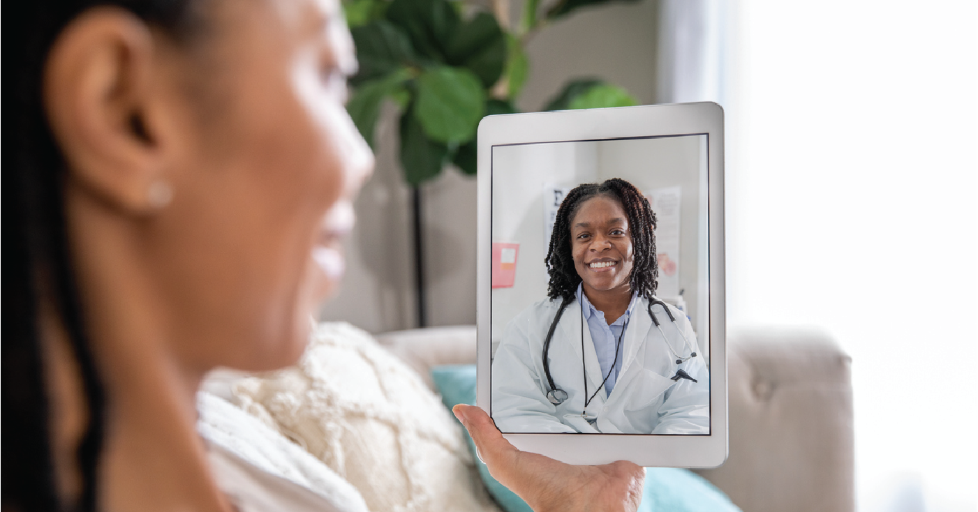 Adult woman at home using a tablet device during a telemedicine visit with her female doctor.
