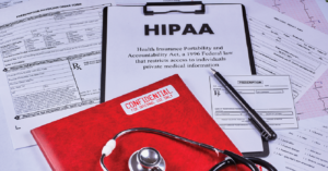 Navigating HIPAA compliance - A doctor’s stethoscope along with other patient health records on a table.