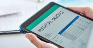 Using automated medical billing software - A doctor holding a tablet device showing a patient’s medical invoice.