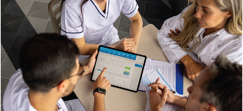 Modern medical practice management strategies - Team of doctors reviewing a patient’s electronic health record using a tablet device.