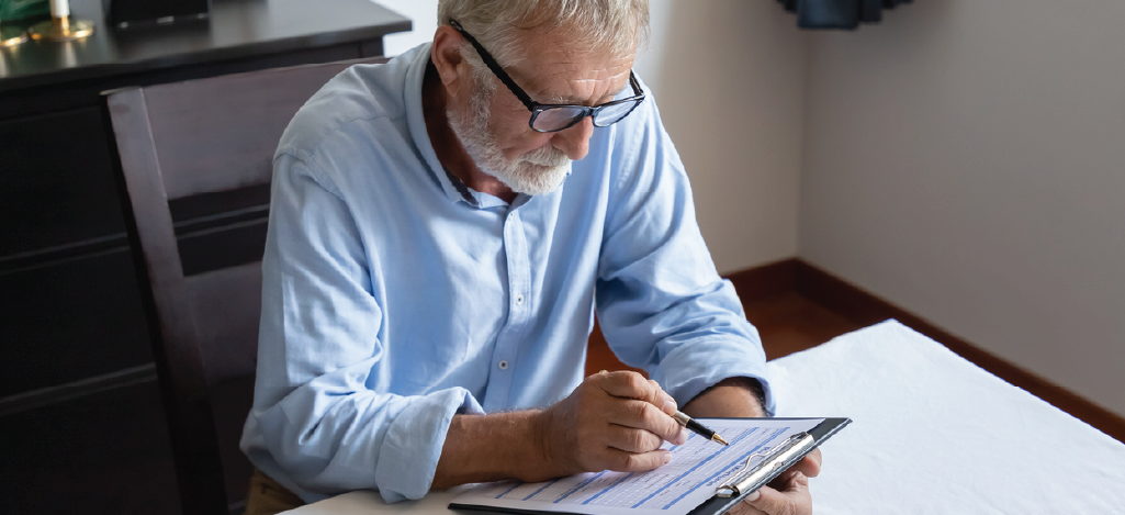 Senior man at home reviewing a Medicare form - reading about Medicare changes.