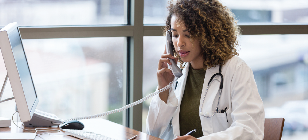 Providing pre-visit billing information - Female doctor speaking with her patient over the phone.