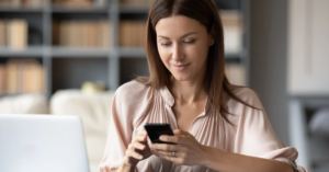 Woman using her phone and computer as an example of patient billing expectations