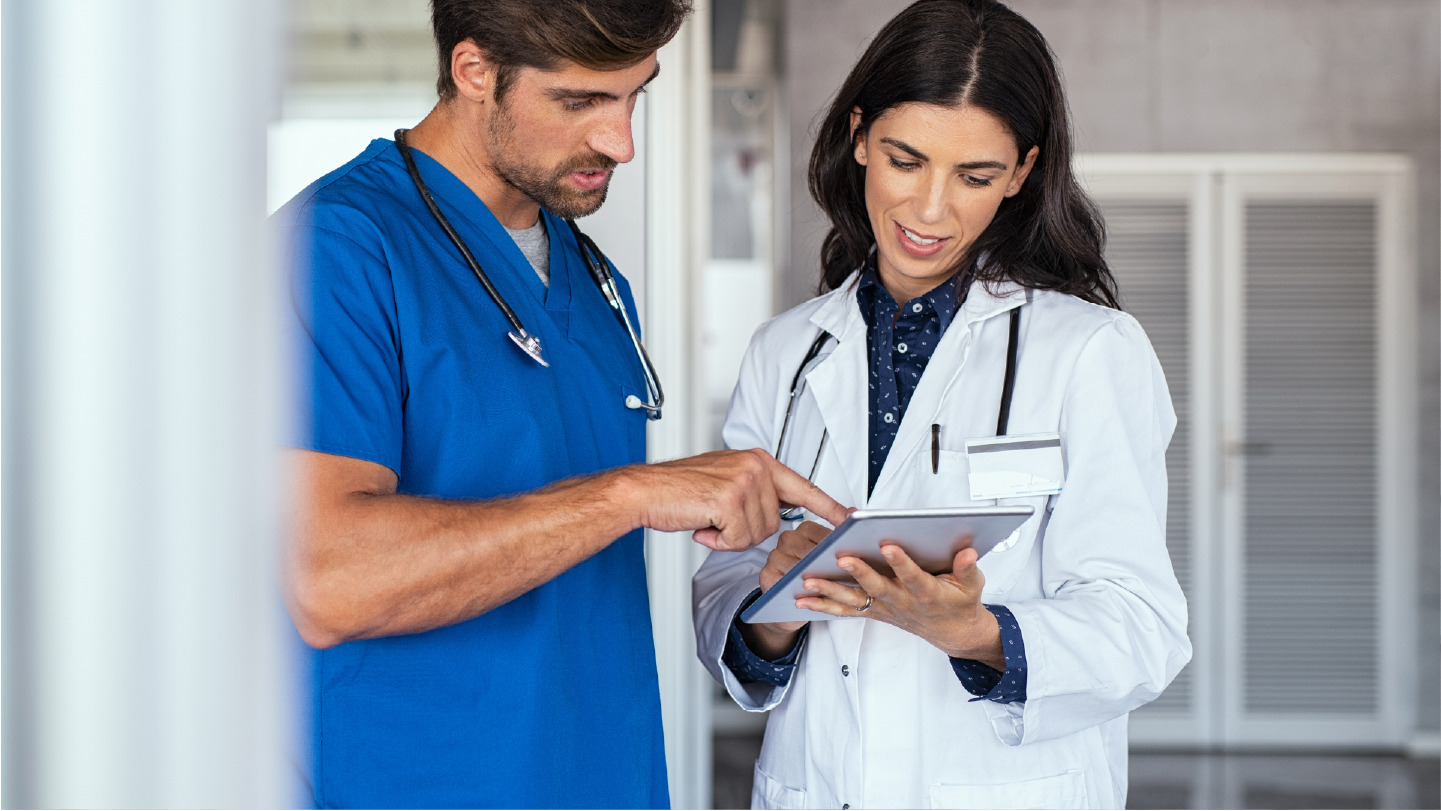 Two doctors talking about an all-in-one billing software while looking at a tablet