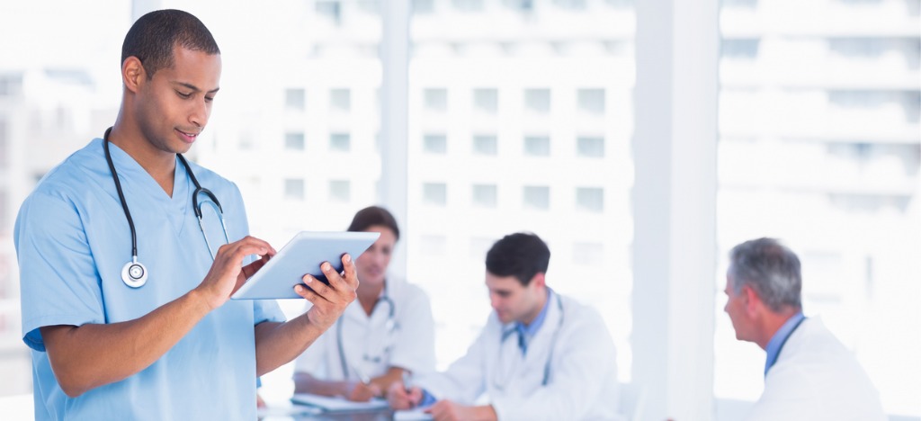 Addressing billing process challenges - A male doctor using a tablet device to check patient billing software.