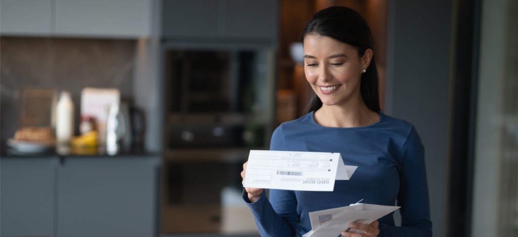 Automation in healthcare - A woman checking her mailed medical bill at home.