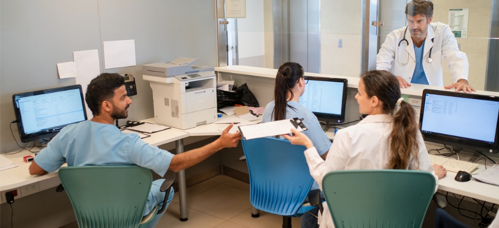 Medical billing technology for tasks - A group of medical professionals checking patient data using computers.