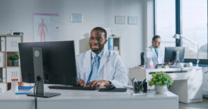 Best RPA software - Two male doctors in an office using different computers to access their practice’s medical software.