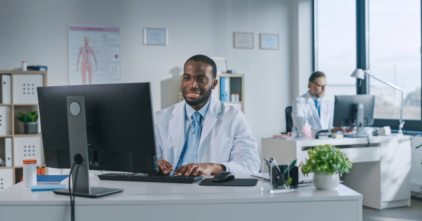 Best RPA software - Two male doctors in an office using different computers to access their practice’s medical software.