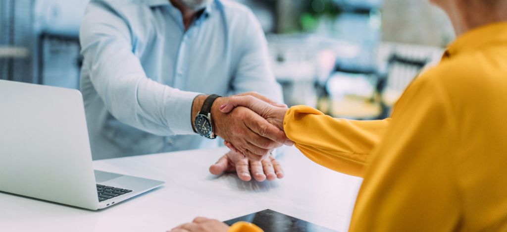 Healthcare Revenue Cycle Management Companies: Two business professionals shaking hands.