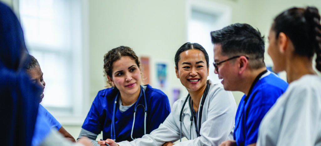 Preventing healthcare burnout - A female doctor having a meeting with her colleagues in an office.