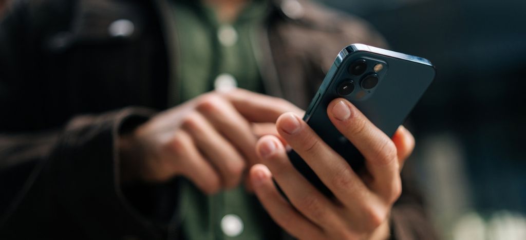 Cropped image of person checking their cellphone deposit automated payment reminder.