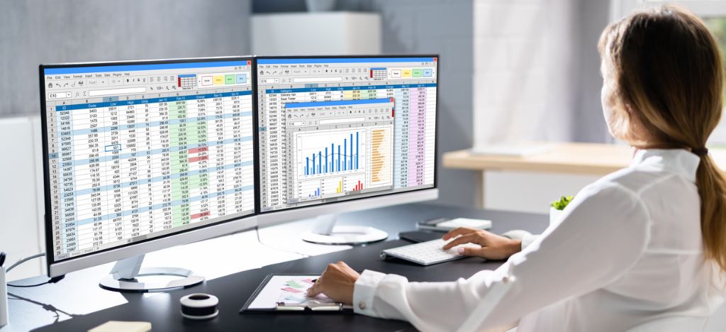 Healthcare Revenue Cycle Management Companies: Data analyst reviewing spreadsheets.
