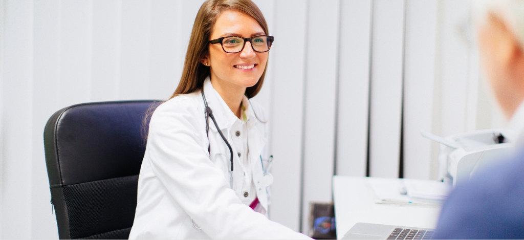 Patient billing support for healthcare providers - A female doctor assisting a senior patient during a medical consultation.