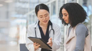 Doctor communicating patient financial responsibility with a tablet.