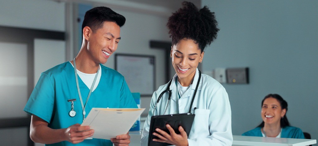 Boosting staff productivity - Two medical professionals reviewing tasks using a tablet device.