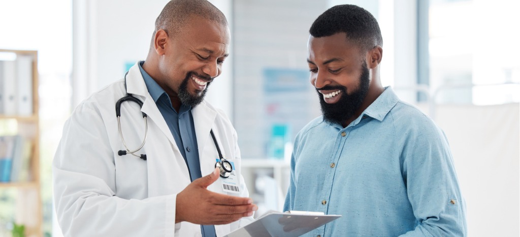 Enhancing patient payment collections - A male doctor explaining medical charges to his male patient.