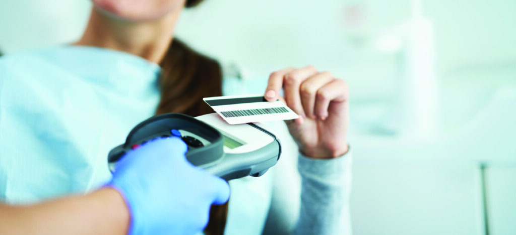  Payment plans for patients who can’t afford dental care - A woman paying her dental bill using a credit card.