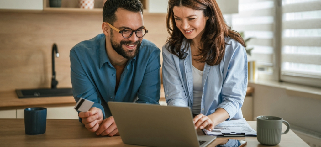 Disadvantages of revenue cycle vendors - A couple at home using their laptop and credit card to settle their medical bills online.