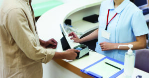 A man paying at a hospital using a smartphone.