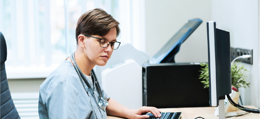 Strategies for medical billing managers - A medical professional checking a patient’s information before inputting it into their practice database.