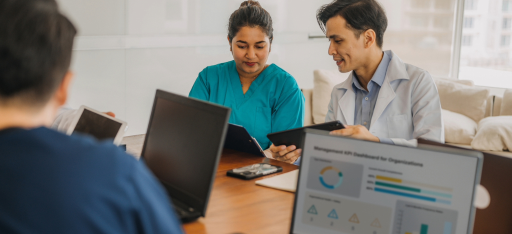 RCM medical billing - A group of doctors discussing their practice’s revenue performance during a meeting.