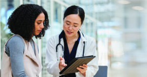 Improving patient communication and satisfaction - A female doctor explaining medical billing options to her female patient.