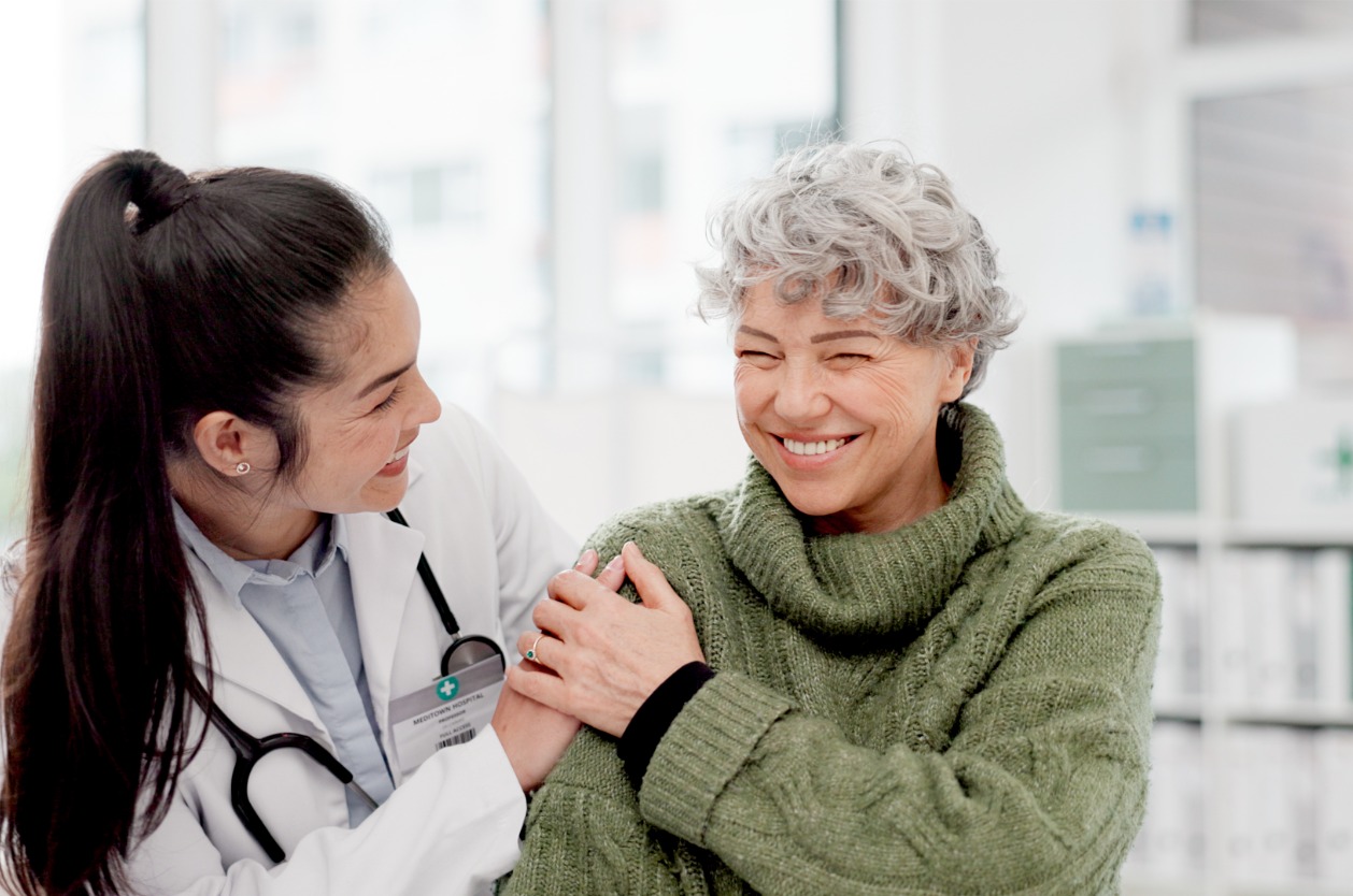 Offering patient financing options - A female doctor assisting a female senior patient in a hospital.
