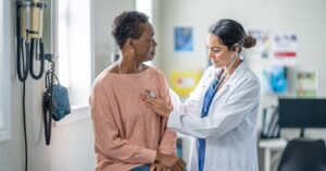 Patient roadmap - A senior woman being checked by a female doctor in a medical clinic.