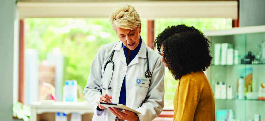 Increasing effective patient communication - A female doctor using a tablet device to explain treatments to her female patient.