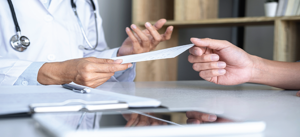Doctor handing a medical bill to his patient - using an effective payment processing system for your practice.