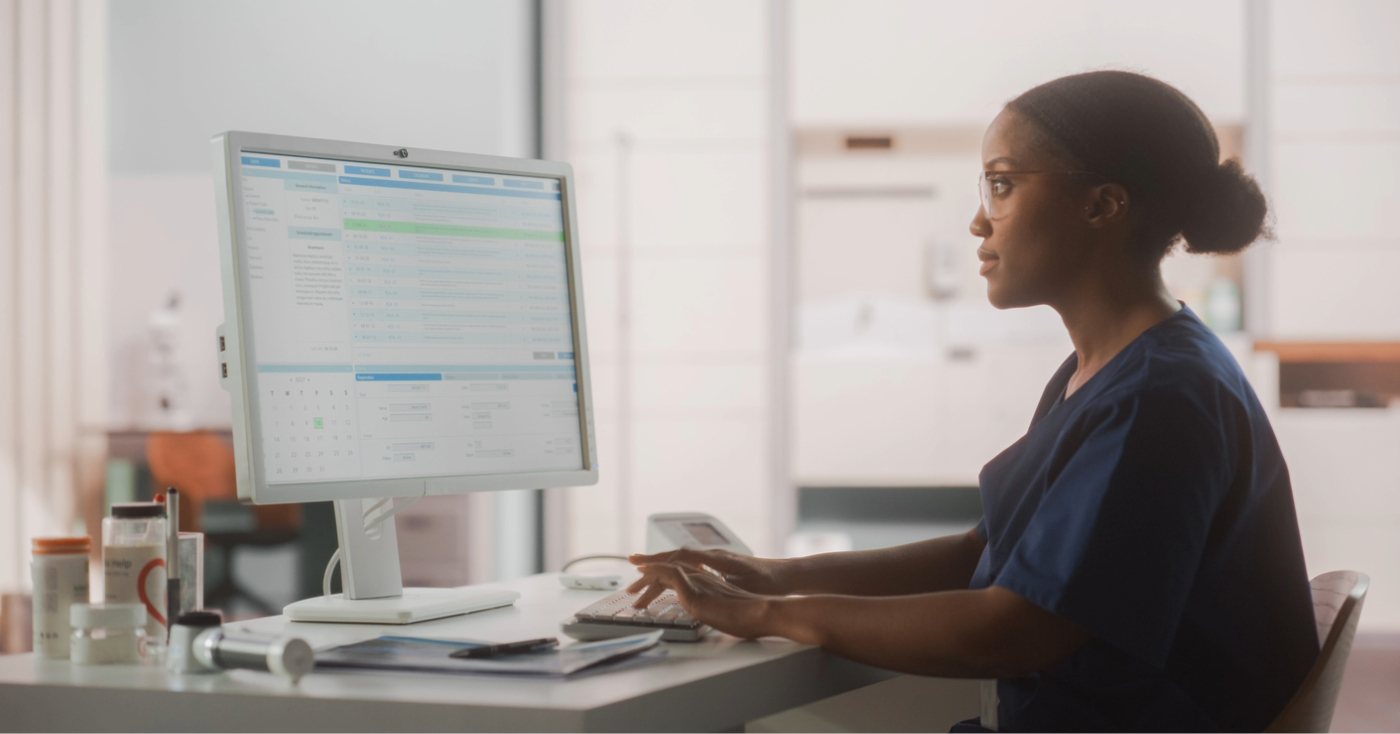 All-in-one communication - A female hospital staff member using a computer to communicate patient bills.