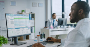 Medical billing software systems - A male doctor using a computer to access his practice’s medical billing software.