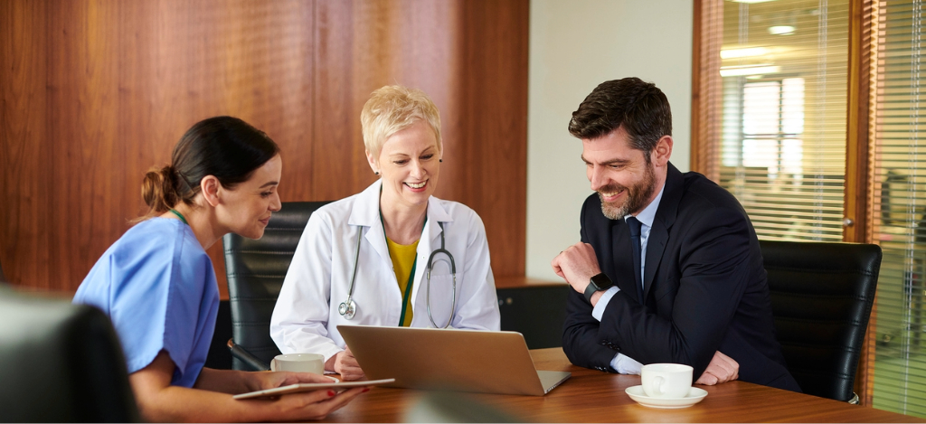 Healthcare RCM companies - Two healthcare professionals having a meeting with a male business partner.