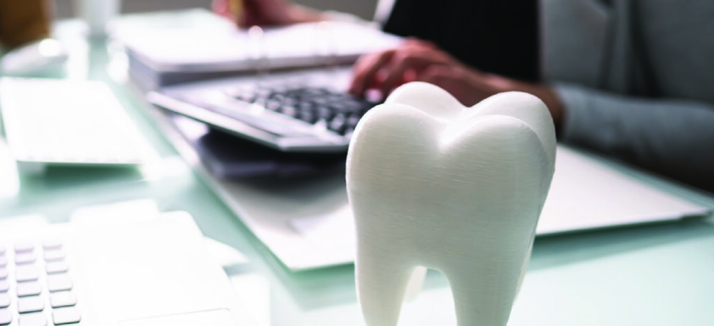 Managing patients who can’t afford dental care - A female dentist computing a patient’s dental treatment bill.