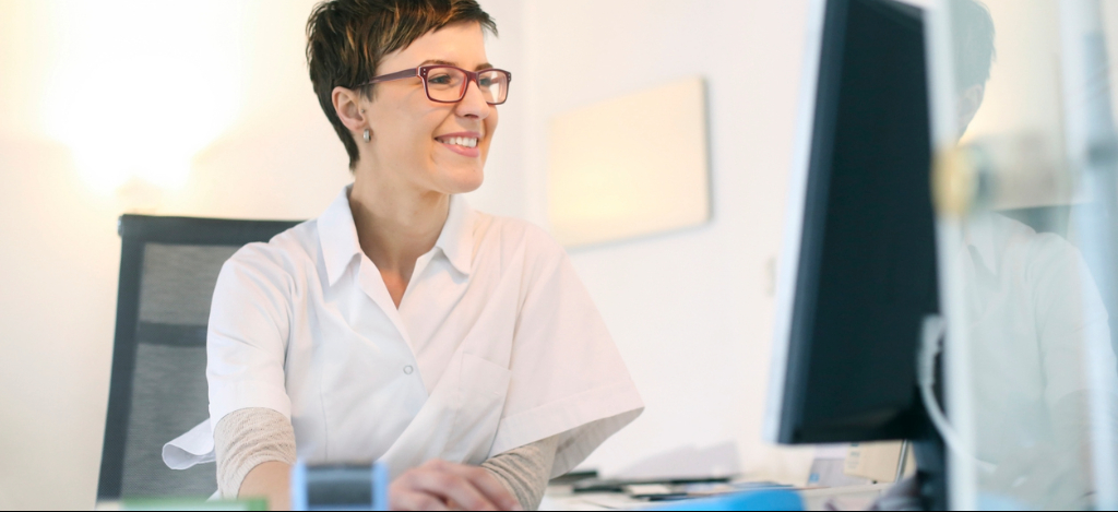 Dialysis Billing Challenges: A medical office manager working at their desktop computer.
