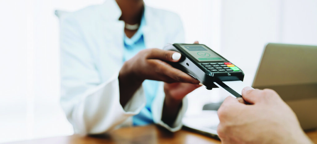 Convenient methods to pay - A female doctor assisting a male patient in paying his medical bill using a credit card.