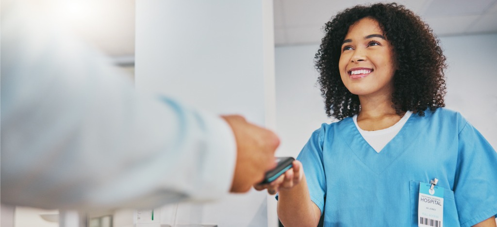 Improving the patient roadmap - A female hospital staff helping a patient pay his medical bills.