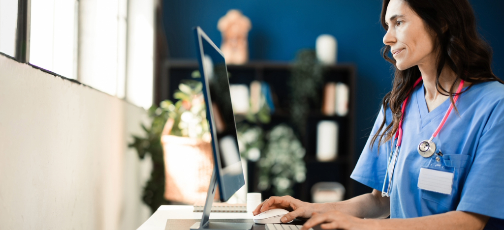 A female doctor in her office using a computer to check patient payments.