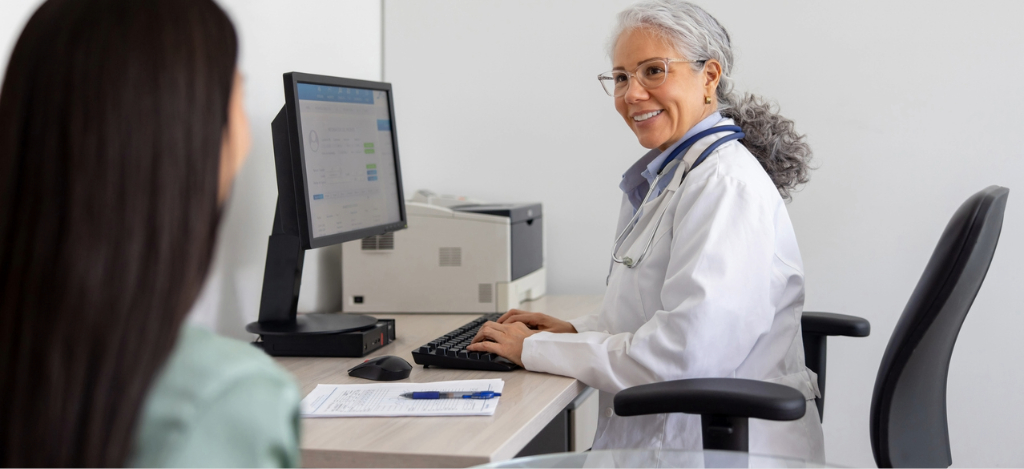 Patient communication platforms - A female doctor assisting her female patient during a medical appointment.