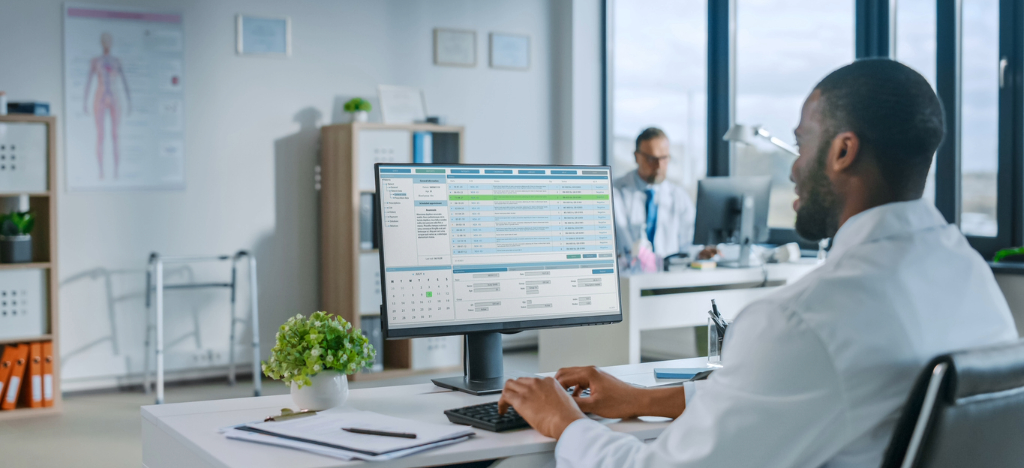 Outsourcing medical billing - A male doctor using a computer to access their practice’s EHR software.