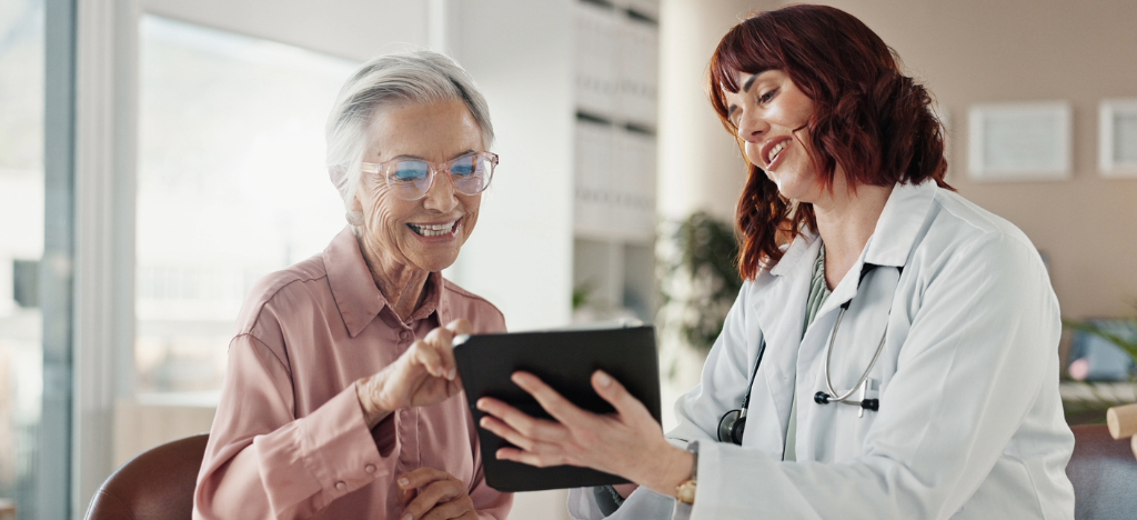 Private practice billing - A female doctor using a tablet device to explain payment options to her female senior patient.