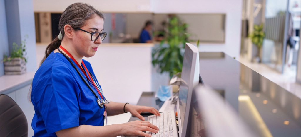 Using EBPP - A female medical professional using a computer to process patient bills.