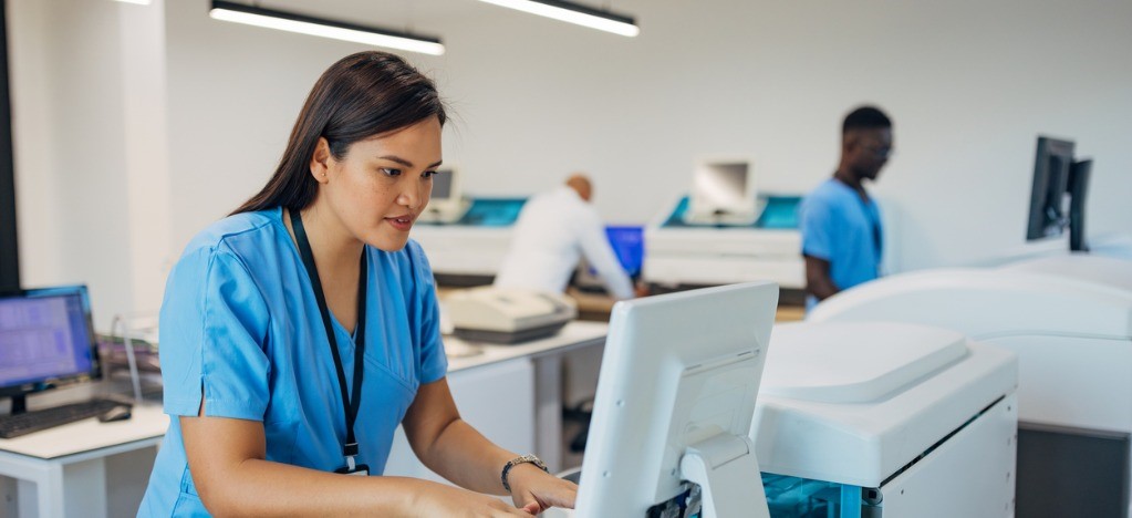 Smart billing solutions for reducing administrative tasks - A female medical professional using a computer to complete patient billing tasks.