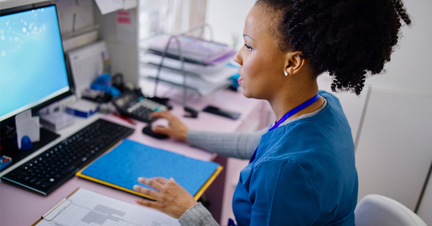 Reducing administrative burden - A female medical staff using a computer to check patient data.