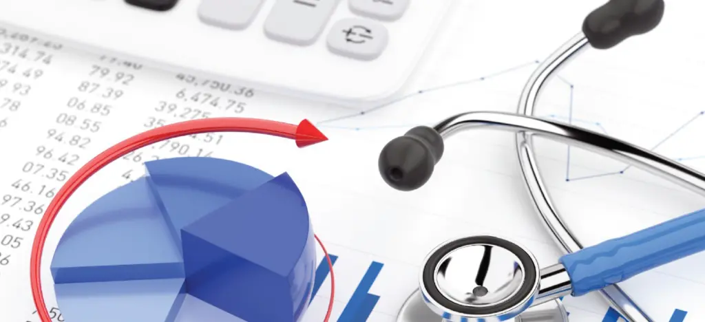 13 step of revenue cycle management - Financial reports on a table with a calculator and a doctor’s stethoscope.