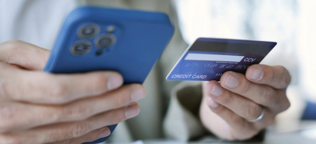 Medical billing software for small practices - A male patient paying his medical bill using his credit card and smartphone.