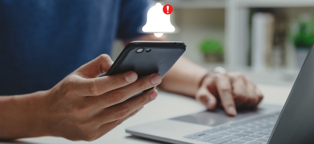 Improving payment collections - A man using a smartphone showing a billing notification icon.