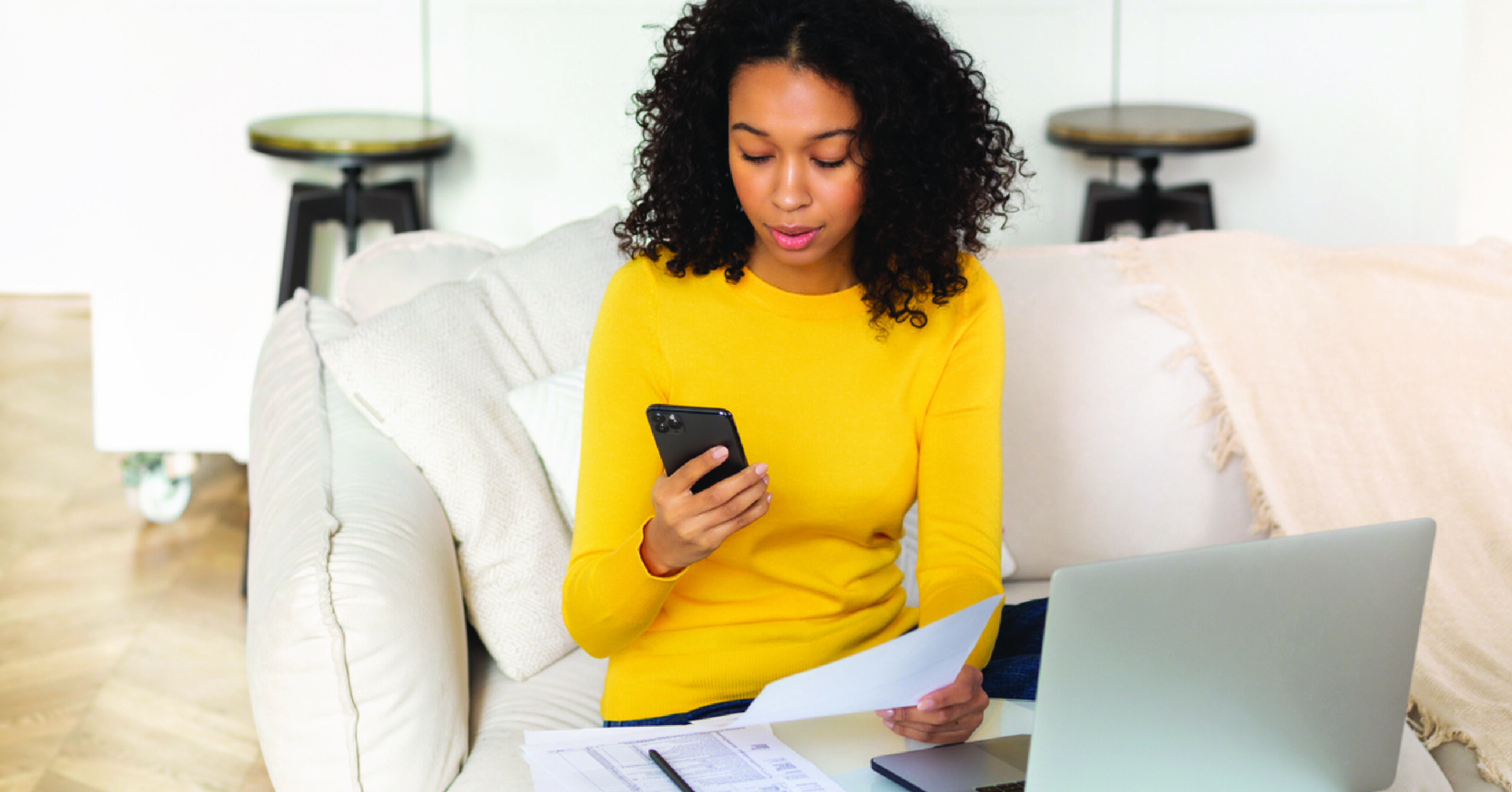 Sending automated reminders - A woman at home checking an automated billing notification on her phone.