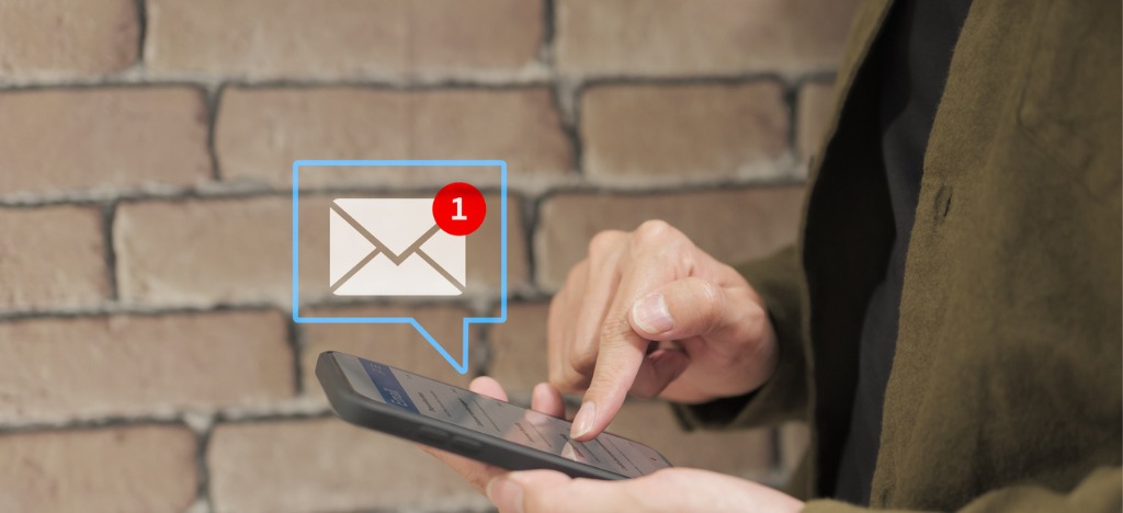 Sending automated payment reminders - A man using a smartphone to check his emails.